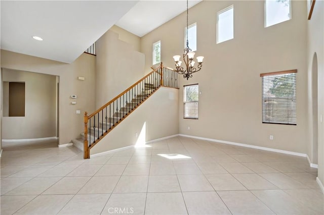 unfurnished room with light tile patterned floors, stairs, baseboards, and a notable chandelier