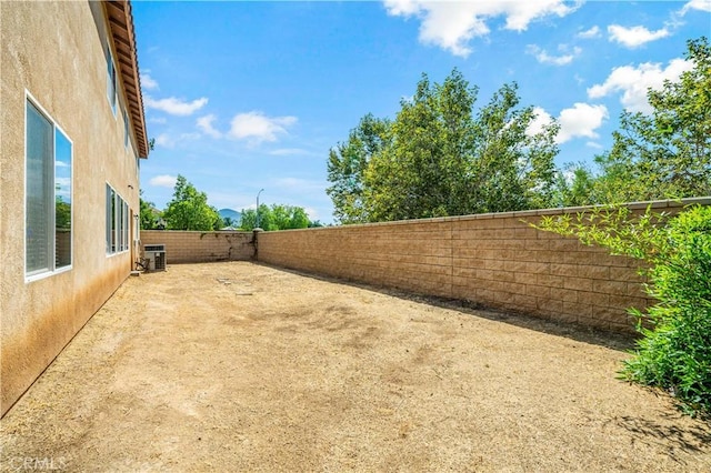 view of yard featuring central AC and a fenced backyard