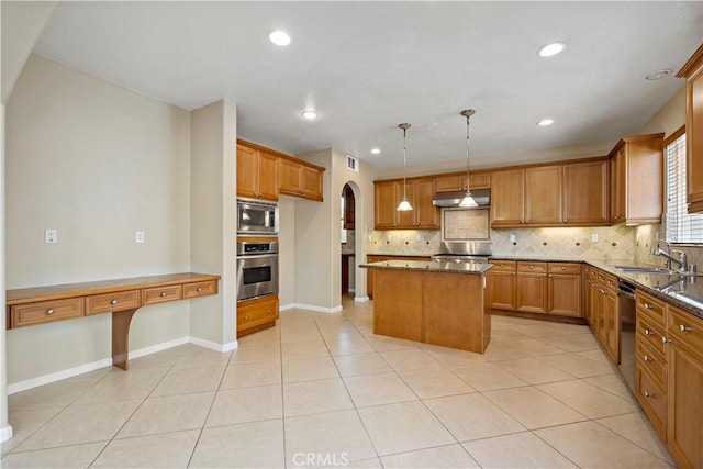 kitchen featuring stainless steel appliances, a sink, a kitchen island, hanging light fixtures, and dark stone counters