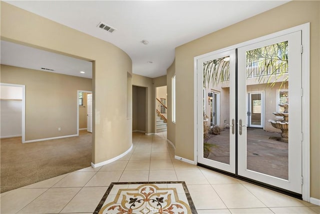 doorway featuring light tile patterned floors, baseboards, stairs, and visible vents