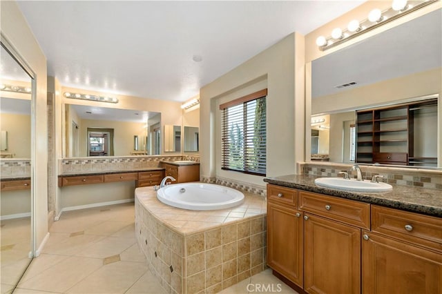 bathroom featuring a bath, tile patterned flooring, vanity, and decorative backsplash