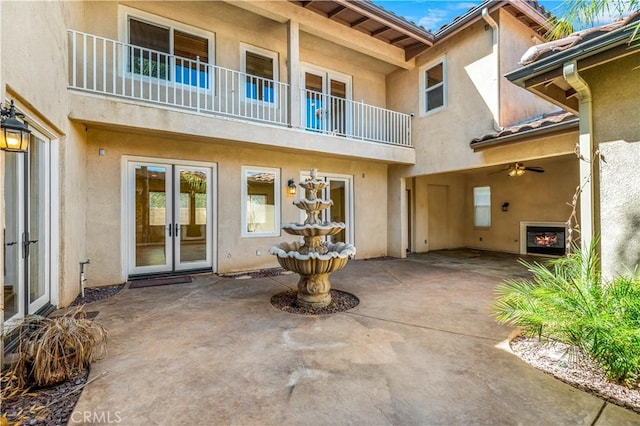 doorway to property with a patio, french doors, a tiled roof, and stucco siding