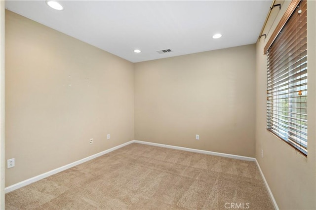 spare room featuring recessed lighting, light colored carpet, visible vents, and baseboards