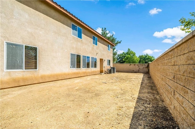 view of yard with a fenced backyard and central AC