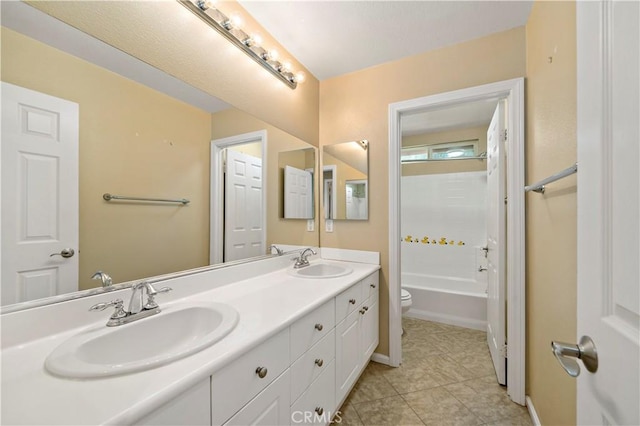 bathroom featuring toilet, tile patterned flooring, double vanity, and a sink