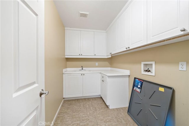 washroom featuring hookup for a washing machine, a sink, visible vents, baseboards, and cabinet space