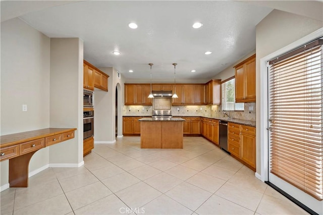 kitchen with stainless steel appliances, hanging light fixtures, a center island, tasteful backsplash, and brown cabinetry