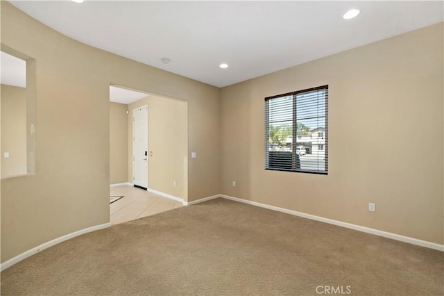 empty room with baseboards, recessed lighting, and light colored carpet