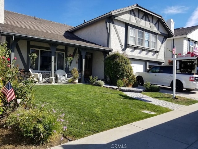 view of front facade with a garage, a front lawn, and a porch