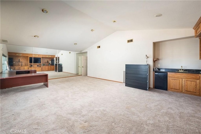 unfurnished living room with sink, lofted ceiling, and light carpet