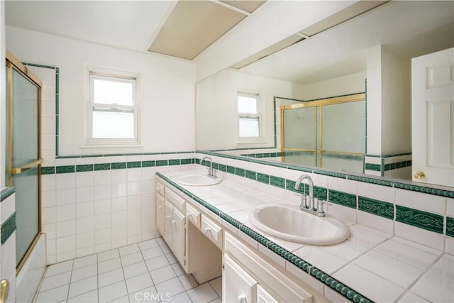 bathroom with a wealth of natural light, tile walls, vanity, and tile patterned floors