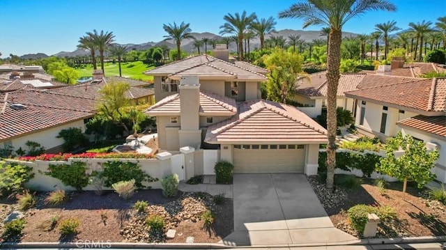 mediterranean / spanish-style house with a mountain view and a garage