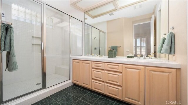 bathroom featuring a shower with door, vanity, and tile patterned flooring