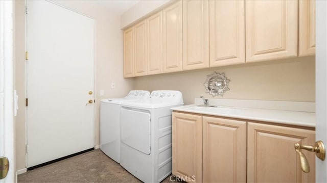 laundry room featuring cabinets, separate washer and dryer, and sink