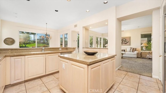 kitchen featuring light carpet, decorative light fixtures, plenty of natural light, and sink