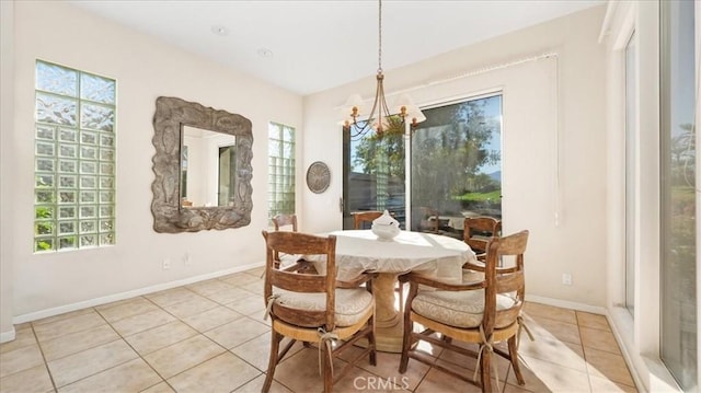 tiled dining space featuring an inviting chandelier and plenty of natural light