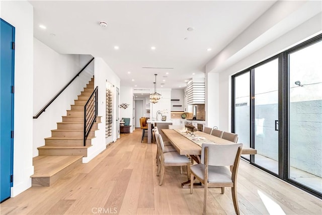 dining area with light hardwood / wood-style flooring, a notable chandelier, and a healthy amount of sunlight