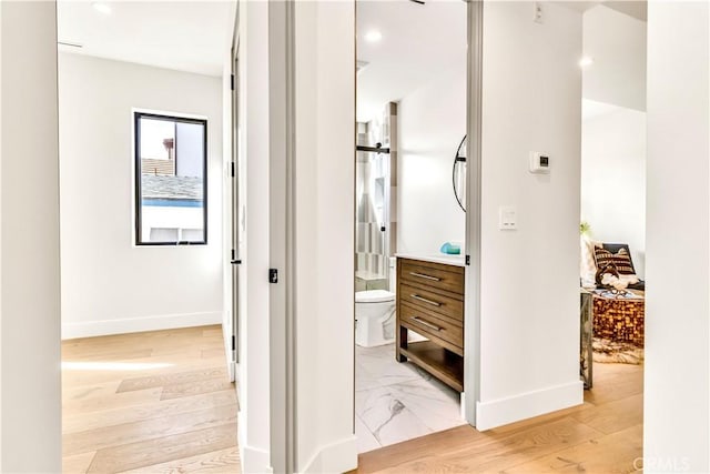 bathroom with toilet, vanity, and hardwood / wood-style flooring