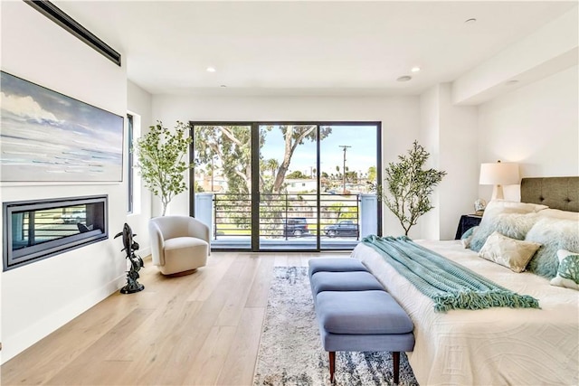 bedroom with light hardwood / wood-style floors and access to outside