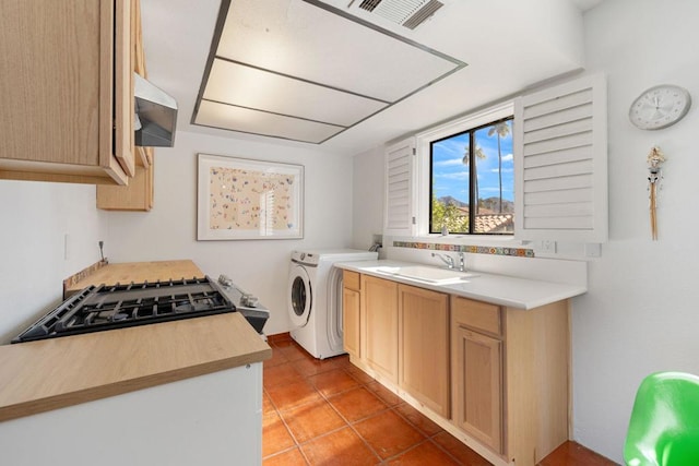 laundry area featuring light tile patterned flooring, separate washer and dryer, and sink