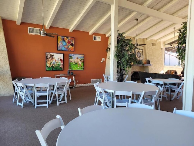 dining space with vaulted ceiling with beams, ceiling fan, and dark colored carpet