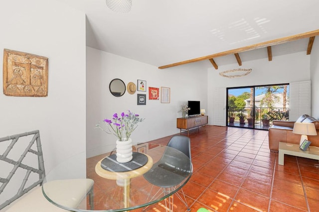 tiled dining area featuring beam ceiling