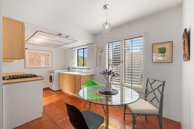 dining room with sink, light tile patterned floors, and washer / dryer