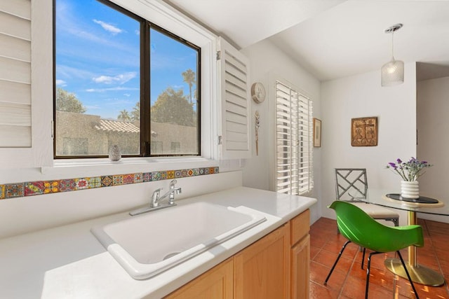 interior space featuring pendant lighting, light brown cabinets, tile patterned floors, and sink