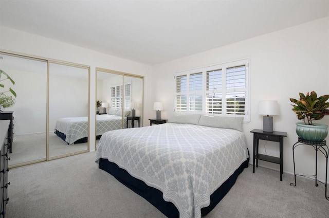 carpeted bedroom featuring multiple closets