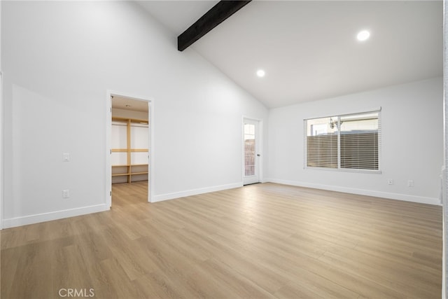 spare room with beamed ceiling, high vaulted ceiling, and light hardwood / wood-style flooring