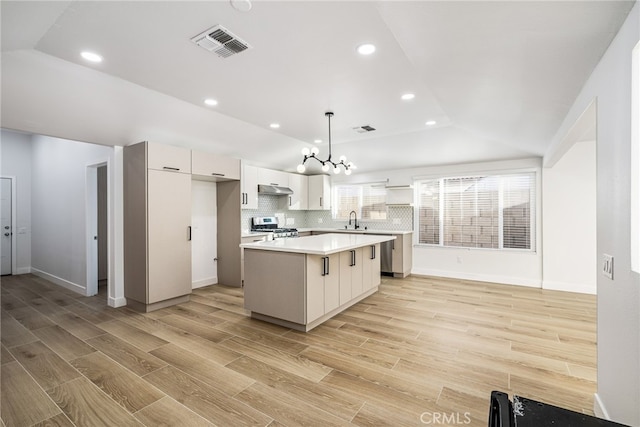 kitchen featuring a center island, hanging light fixtures, stainless steel range oven, and light wood-type flooring