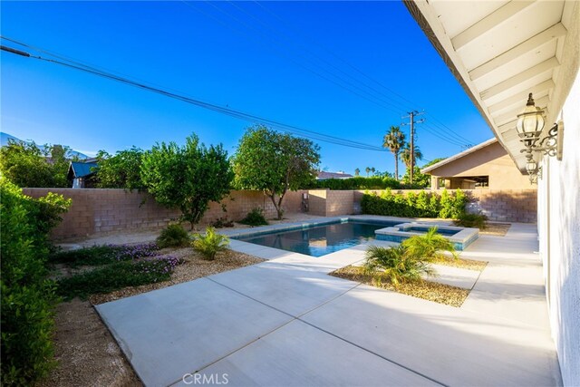 view of swimming pool featuring an in ground hot tub and a patio