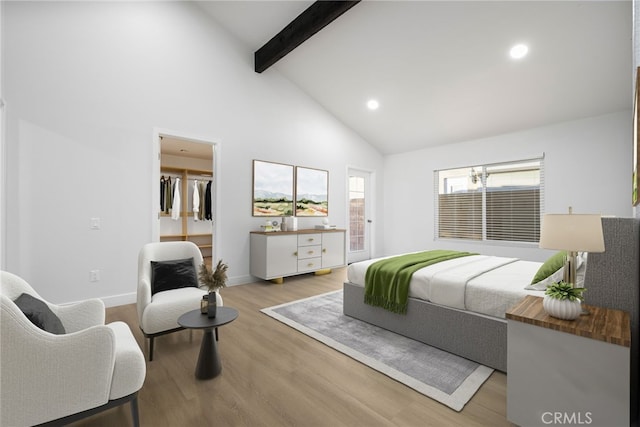 bedroom featuring light hardwood / wood-style floors, beam ceiling, high vaulted ceiling, and ensuite bath