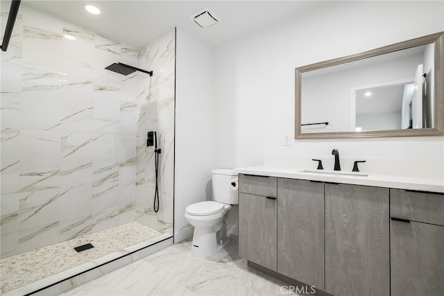 bathroom featuring tiled shower, vanity, and toilet