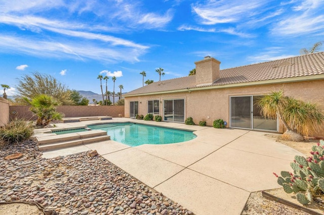 view of swimming pool featuring a patio area and an in ground hot tub