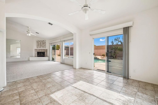 unfurnished living room with ceiling fan, light colored carpet, and vaulted ceiling