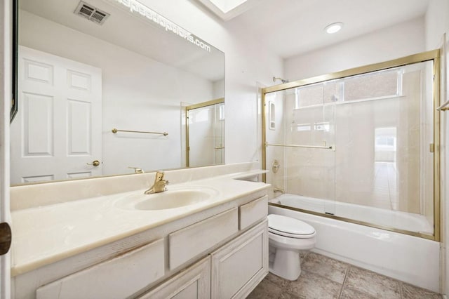 full bathroom with tile patterned flooring, toilet, combined bath / shower with glass door, and vanity