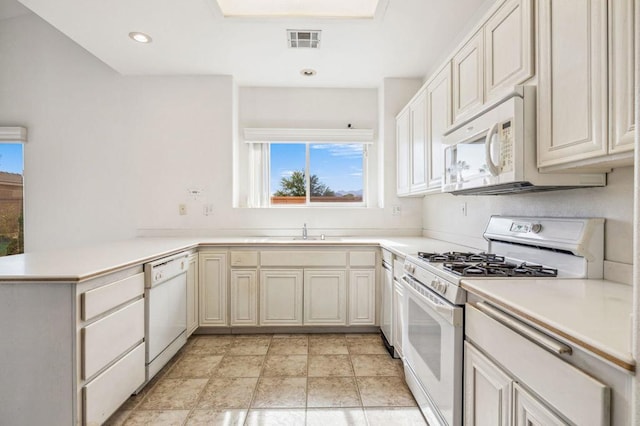 kitchen with sink, white appliances, and kitchen peninsula