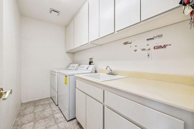 laundry room featuring cabinets, sink, and washing machine and clothes dryer