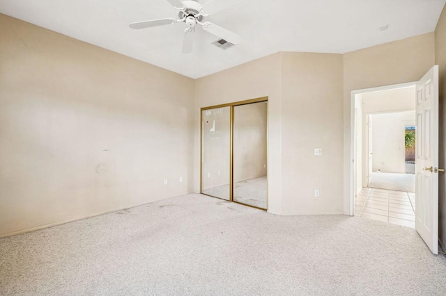 unfurnished bedroom featuring light colored carpet, a closet, and ceiling fan