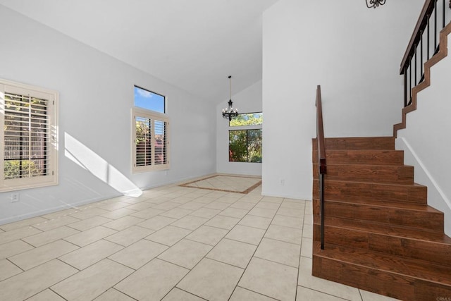 tiled foyer featuring high vaulted ceiling and a chandelier