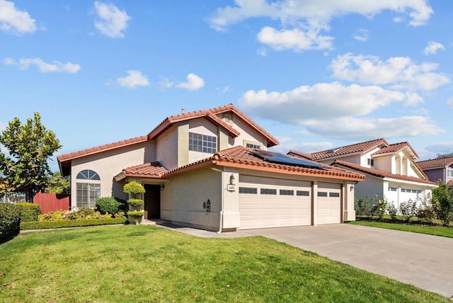 mediterranean / spanish house featuring solar panels, a garage, and a front yard