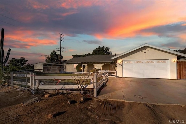 single story home with driveway, an attached garage, fence, and stucco siding