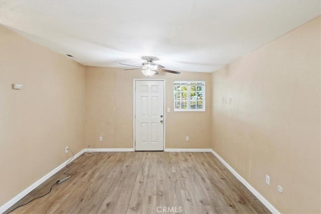 empty room featuring light wood-style flooring, baseboards, and ceiling fan