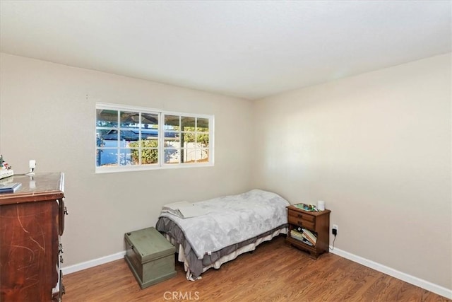 bedroom featuring baseboards and wood finished floors