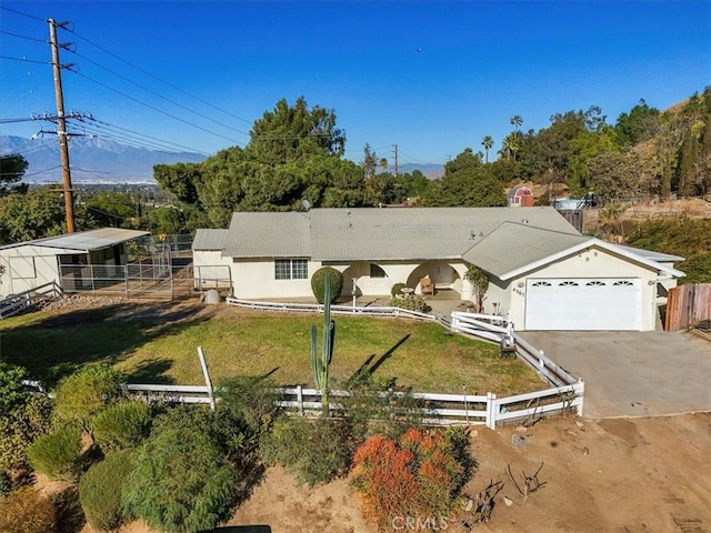 view of front of house featuring an attached garage, fence, driveway, stucco siding, and a front yard