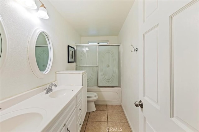 full bathroom featuring double vanity, combined bath / shower with glass door, a sink, and tile patterned floors