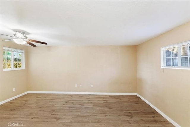 spare room with ceiling fan, baseboards, and wood finished floors