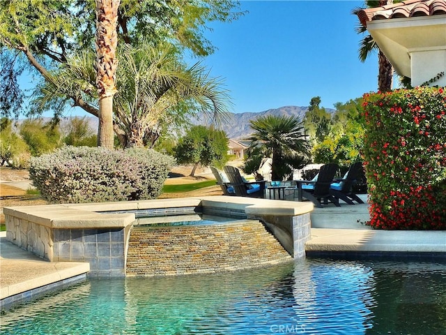 view of pool featuring a mountain view and an in ground hot tub