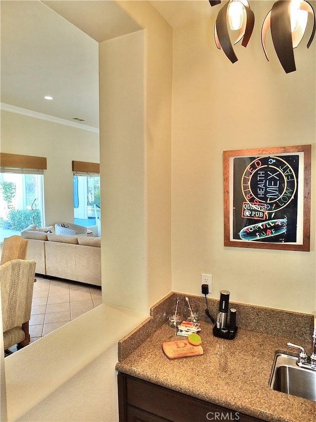 interior space with sink, ornamental molding, and tile patterned flooring